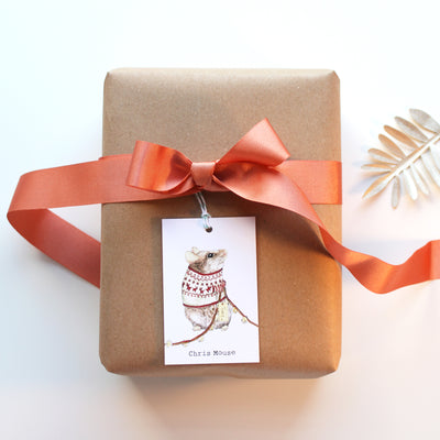 Wrapped gift with a Chris Mouse Gift Tag and ribbon